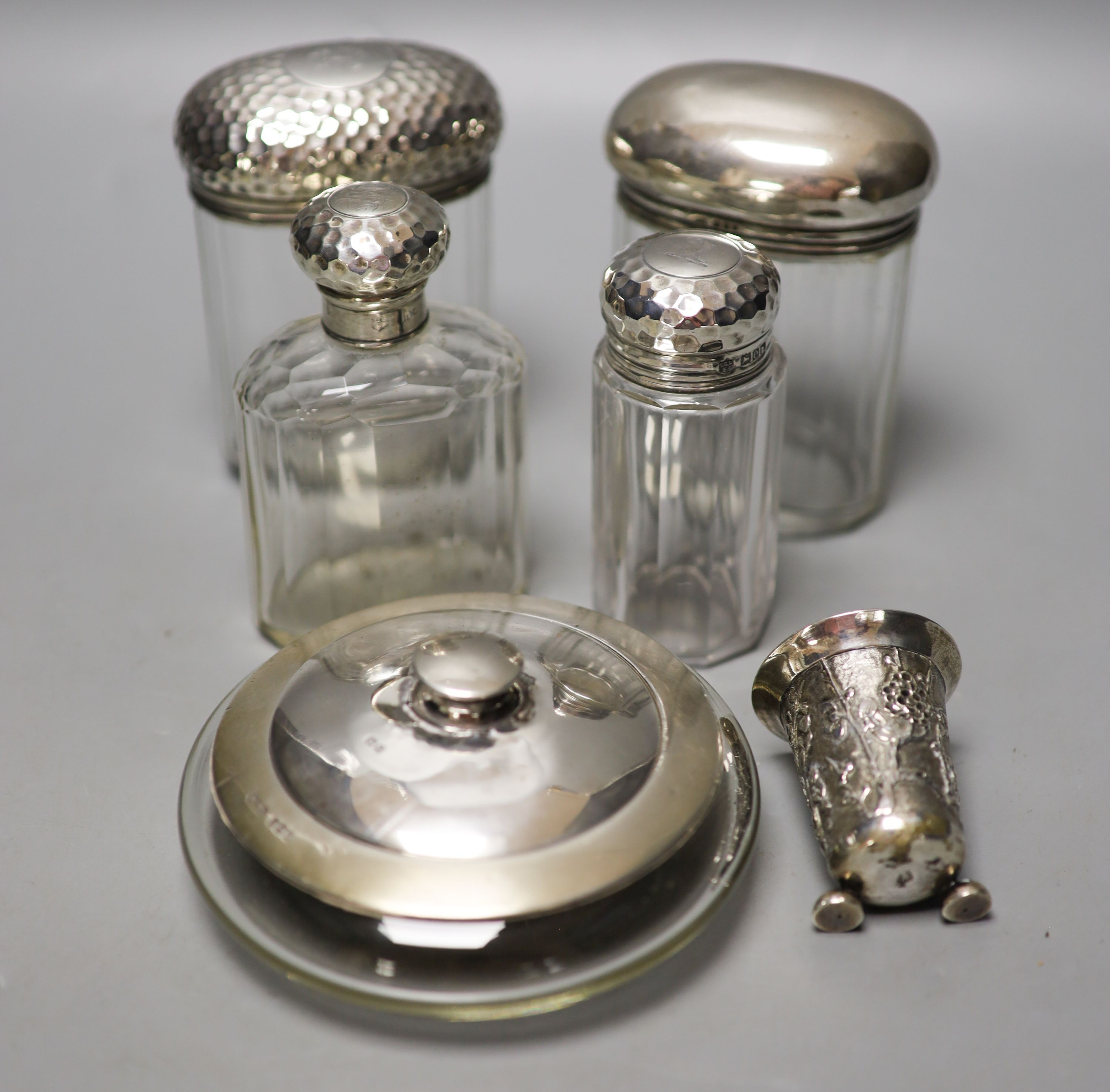 Six assorted silver mounted glass toilet jars, including a powder bowl and a Chinese white metal tot(a.f.).